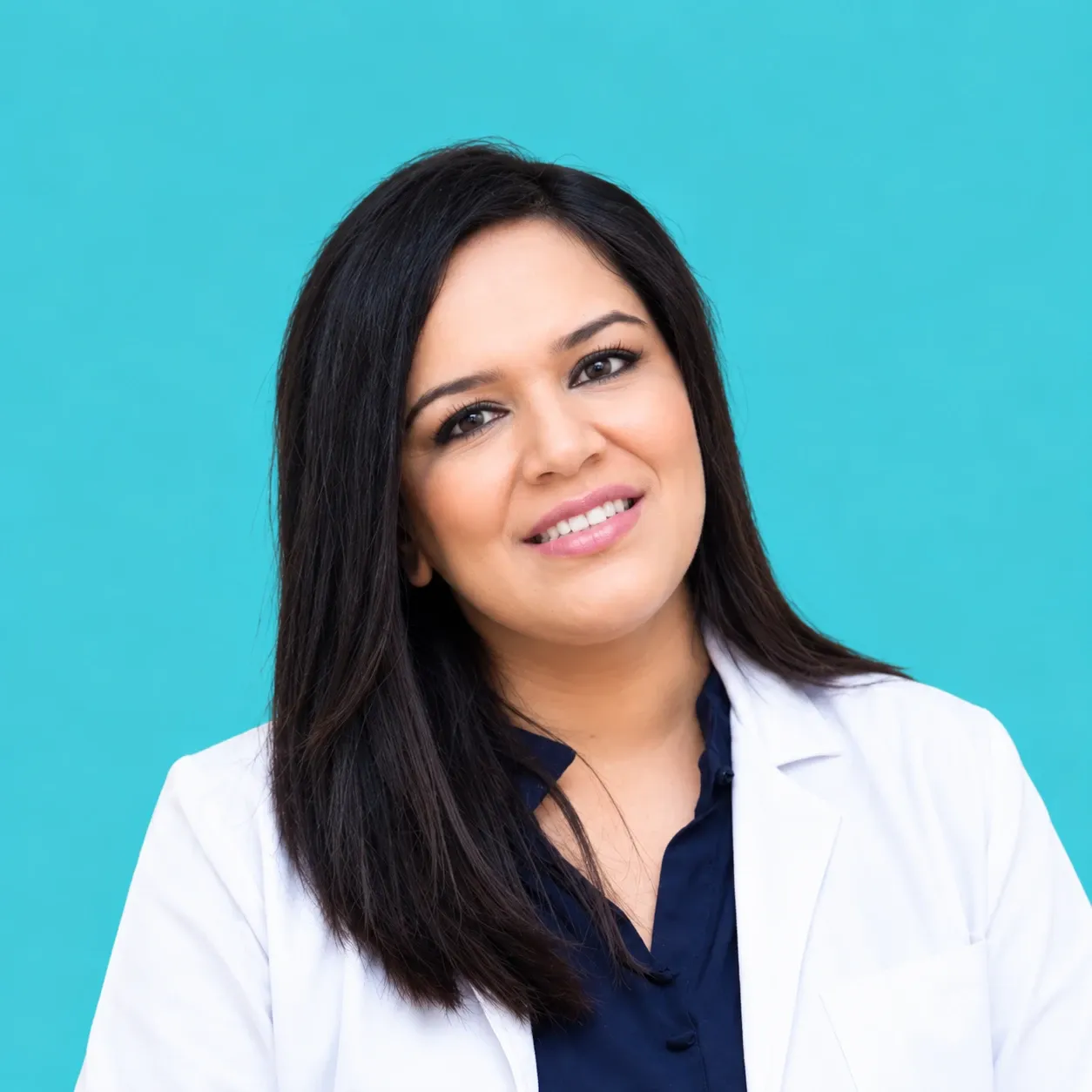 Malvika Fulwani in a white coat, smiling.